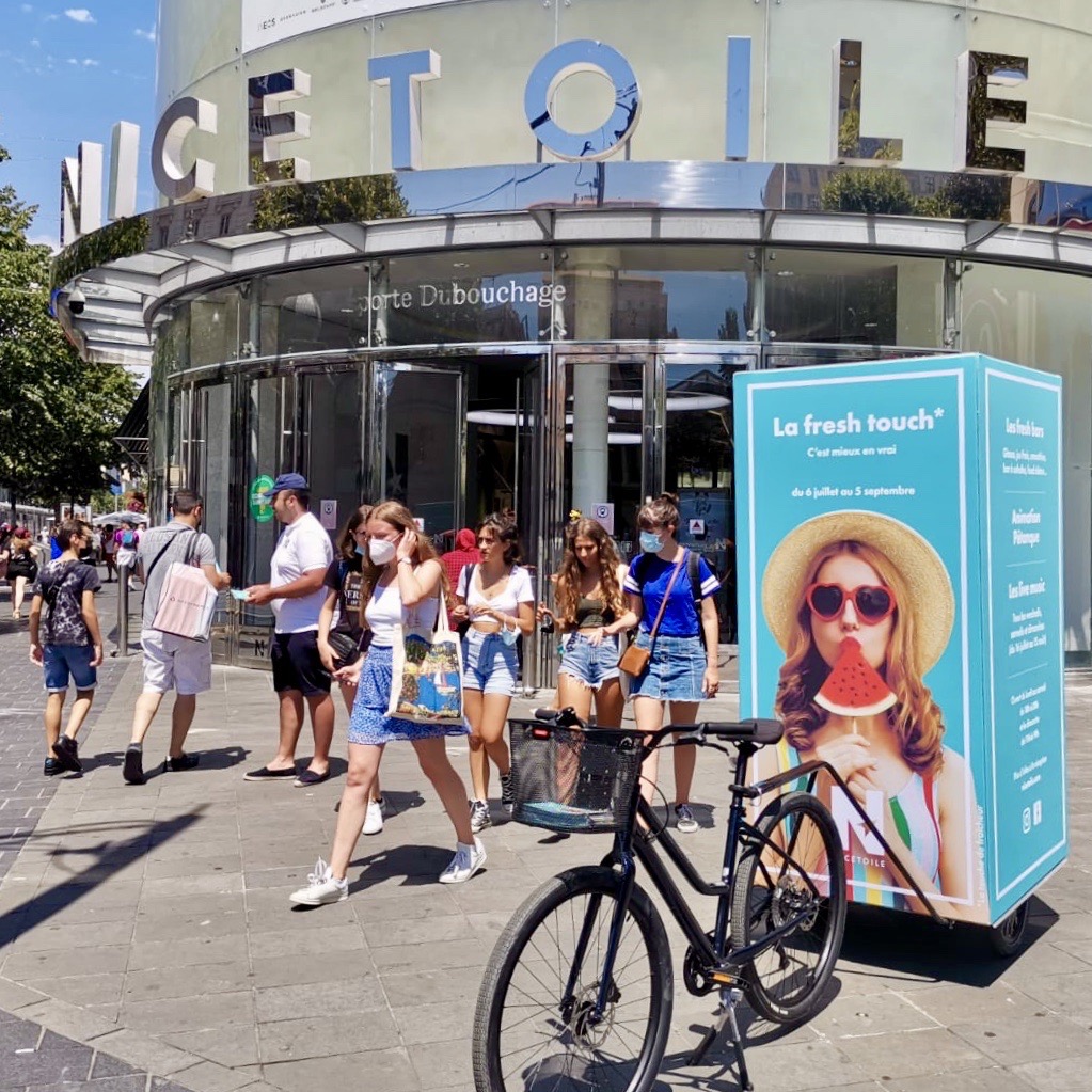 Velo Expo le centre commercial Nicetoile à Nice. Affichage mobile, animation retail drive-to-store, distribution de flyers avec vélo triporteur et remorque affichage mobile cube grand format. Campagne communication ooh hors-media par activation affichage mobile digital avec vélo triporteur publicitaire street marketing | Velo Expo | Agence Veymont